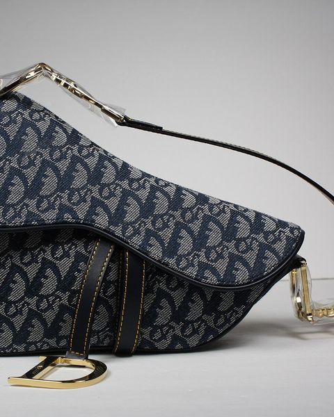 A navy Dior Saddle bag in monogram logo print with D charm